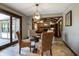 An elegant dining room with a glass table, four upholstered chairs and an eye-catching chandelier, with access to outdoor patio at 160 Scranton Ct, Zionsville, IN 46077