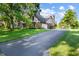 This home features a long driveway, a brick and tudor style, and mature landscaping at 160 Scranton Ct, Zionsville, IN 46077
