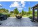 A lovely outdoor stone patio features a table and chairs, with views of the home's manicured backyard at 160 Scranton Ct, Zionsville, IN 46077