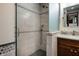 Modern shower with glass door, tile surround, hand held sprayer, and dark wood vanity at 160 Scranton Ct, Zionsville, IN 46077