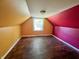 Attic bedroom with painted walls and hardwood floors, waiting for an imaginative update at 1601 E 44Th St, Indianapolis, IN 46205