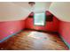 Attic bedroom with a single window and hardwood floors, primed for a creative renovation at 1601 E 44Th St, Indianapolis, IN 46205