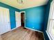 Bright blue bedroom featuring hardwood floors and natural light, ready to be refreshed at 1601 E 44Th St, Indianapolis, IN 46205