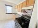 Kitchen featuring wood cabinets, black appliances, and a window at 1601 E 44Th St, Indianapolis, IN 46205
