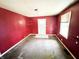 Spacious red living room with carpet flooring and a white door at 1601 E 44Th St, Indianapolis, IN 46205