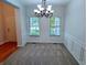 Bright dining room featuring a modern chandelier, large windows, and wainscoting detail at 16254 Quartz Dr, Noblesville, IN 46060