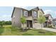 Two-story home with green grass, brown and beige siding, attached two car garage, and covered front porch at 1911 Goodwin Pl, Westfield, IN 46074