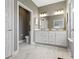 Modern bathroom with marble floors, a double sink vanity, framed mirror, and separate toilet room at 19959 Cowie Ln, Westfield, IN 46074