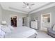 A neutral bedroom features an adjoining bath, closet, dresser, ceiling fan and carpeted floors at 19959 Cowie Ln, Westfield, IN 46074