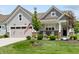 Charming home featuring a two-car garage, landscaped lawn, brick accents and cozy front porch with rocking chairs at 19959 Cowie Ln, Westfield, IN 46074