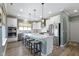 Bright kitchen boasts a large island, stainless steel appliances, white cabinets, and stylish pendant lighting at 19959 Cowie Ln, Westfield, IN 46074