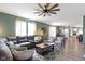 This living room with hardwood floors features a ceiling fan, natural light, and comfortable seating at 19959 Cowie Ln, Westfield, IN 46074