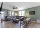 Open-concept living room with comfortable seating, natural light, and modern ceiling fan at 19959 Cowie Ln, Westfield, IN 46074