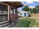 View of the backyard and detached garage with a bright blue door, fenced in for privacy and security at 2001 S Jefferson St, Muncie, IN 47302