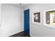 Entryway featuring a blue door, window, and dark floors at 2001 S Jefferson St, Muncie, IN 47302