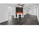 Spacious living room with hardwood floors, a brick fireplace, and multiple ceiling fans at 2001 S Jefferson St, Muncie, IN 47302