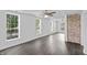 Open living area featuring hardwood floors, large windows, ceiling fans, and a brick accent wall at 2001 S Jefferson St, Muncie, IN 47302