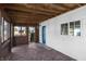 Cozy covered patio with wooden flooring and blue door at 2001 S Jefferson St, Muncie, IN 47302