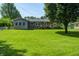 The backyard offers plenty of green space, bordered by mature trees and a chain link fence at 2020 Rosedale Dr, Indianapolis, IN 46227