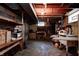 This is a well-lit basement workshop featuring open wood rafters, shelving, and room for storage and crafting at 2020 Rosedale Dr, Indianapolis, IN 46227