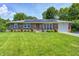 Charming single-story brick home with solar panels, a well-manicured lawn, and mature landscaping at 2020 Rosedale Dr, Indianapolis, IN 46227