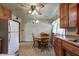 Functional kitchen with wooden cabinets, white appliances, and a dining area at 2020 Rosedale Dr, Indianapolis, IN 46227