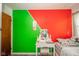 This bedroom boasts creative decor and a vanity space, highlighted by eye-catching green and red wall accents at 2113 W Barcelona Dr, Muncie, IN 47304