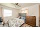 A serene bedroom is showcased with a comfortable bed, soft lighting, and complemented by a dresser and ceiling fan at 2113 W Barcelona Dr, Muncie, IN 47304