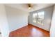 Sunlit bedroom with hardwood floors, featuring a ceiling fan, large window, and neutral paint at 2259 Colfax Ln # 2259, Indianapolis, IN 46260