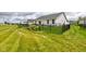 View of a landscaped backyard with a black fence, lush green grass and flower beds at 2500 Sand Hollow Dr, Lebanon, IN 46052