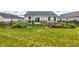 Landscaped backyard with a black fence, lush green grass and flower beds behind the home at 2500 Sand Hollow Dr, Lebanon, IN 46052