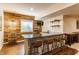 A stylish basement bar with wood paneling, a granite countertop, seating for four, and a wine rack at 2783 W High Grove Cir, Zionsville, IN 46077