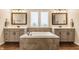 Bright bathroom featuring a soaking tub with tiled surround and double vanity with shaker cabinets at 2783 W High Grove Cir, Zionsville, IN 46077