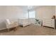Cozy Bedroom with a white crib, neutral rocker, dresser, and a small bookshelf filled with colorful books at 2783 W High Grove Cir, Zionsville, IN 46077