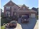 Two-story brick home with manicured lawn and an attached two-car garage and concrete driveway at 2783 W High Grove Cir, Zionsville, IN 46077