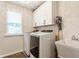 Laundry room features a washer, dryer, a utility sink, and white cabinets above the machines at 2783 W High Grove Cir, Zionsville, IN 46077