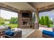 Relaxing covered outdoor patio with brick fireplace and comfortable seating, perfect for entertaining at 2783 W High Grove Cir, Zionsville, IN 46077
