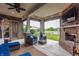 Covered patio with comfortable seating, an outdoor fireplace, and views of the landscaped backyard and pond at 2783 W High Grove Cir, Zionsville, IN 46077