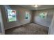 Bright bedroom with neutral paint, carpet flooring, baseboard trim and three windows for natural light at 2807 Carla Ct, Indianapolis, IN 46219