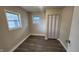 Bright bedroom with neutral paint, hardwood flooring, baseboard trim, two windows, and a closet at 2807 Carla Ct, Indianapolis, IN 46219