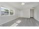 Bright living room with grey wood-look flooring, white walls, and natural light from the windows at 2807 Carla Ct, Indianapolis, IN 46219