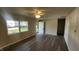 Bright living room with modern flooring, a ceiling fan, and natural light from the large windows and entry door at 2807 Carla Ct, Indianapolis, IN 46219