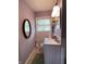 Bathroom featuring an oval mirror, white tiled walls, and a single sink at 2826 Falcon Dr, Indianapolis, IN 46222