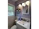 Well-lit bathroom with a modern vanity, mirror, and tiled walls at 2826 Falcon Dr, Indianapolis, IN 46222