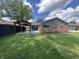 View of the house and backyard featuring a pergola covered patio, lawn, and house elevation at 2845 12Th St, Columbus, IN 47201