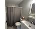 Bathroom features gray shower curtain, vanity with mirror, toilet and decorative plant at 2845 12Th St, Columbus, IN 47201