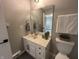 Bathroom featuring marble countertop, vanity with mirror, toilet and a plant accent at 2845 12Th St, Columbus, IN 47201