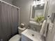 Bathroom features gray shower curtain, vanity with mirror, toilet and decorative plant at 2845 12Th St, Columbus, IN 47201