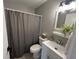 Bathroom features gray shower curtain, vanity with mirror, toilet and decorative plant at 2845 12Th St, Columbus, IN 47201