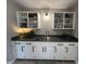 Kitchen wet bar with white cabinets, open shelving, gray countertops, and stainless steel sink at 2845 12Th St, Columbus, IN 47201